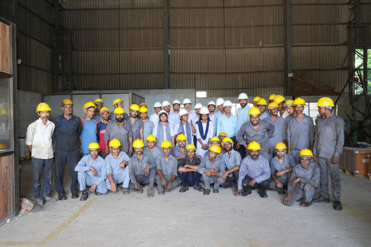 The RIC team in hard hats in the Umbergaon warehouse